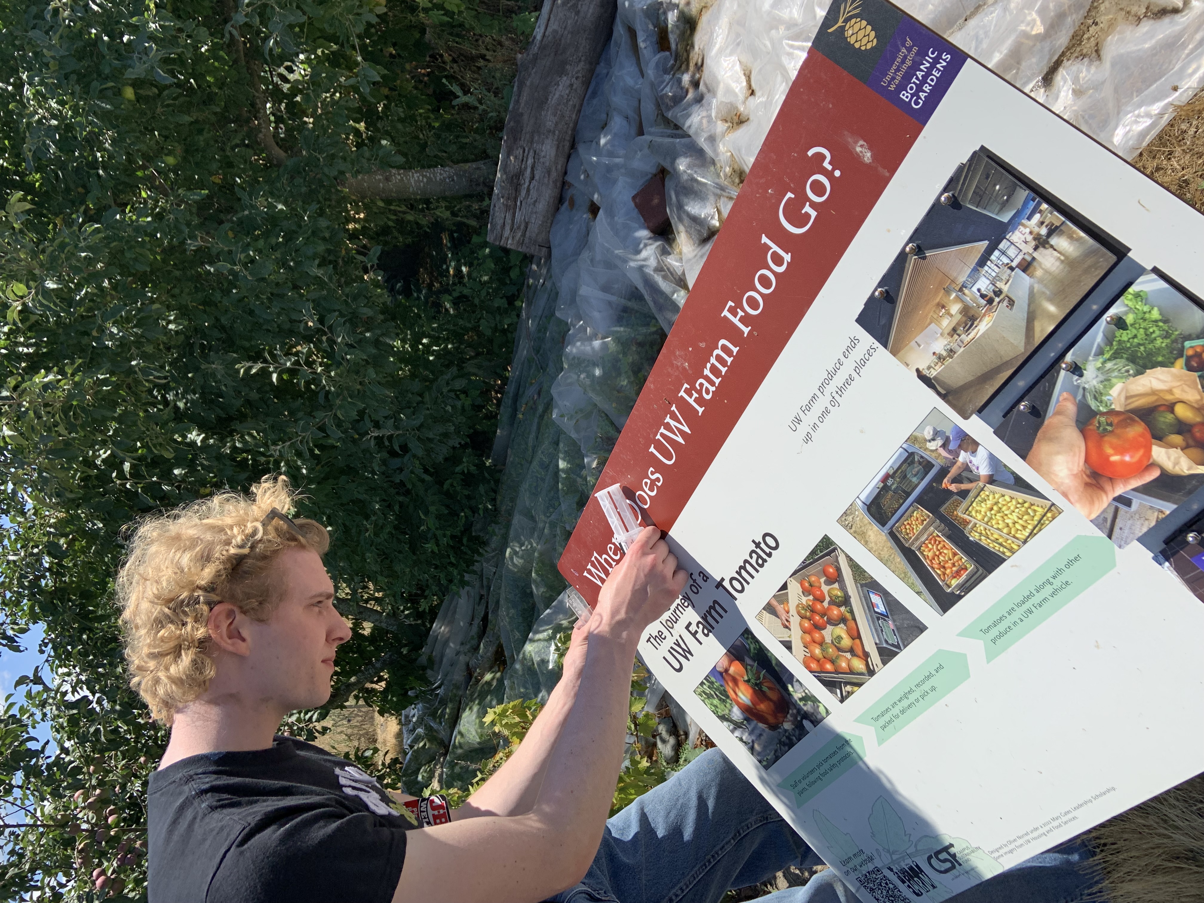 Two farm workers load steel signposts into a truck